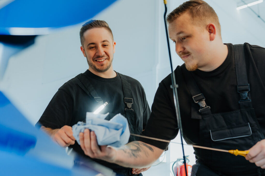 Garagisten in Auto Garage beim P&uuml;fen des &Ouml;lstandes