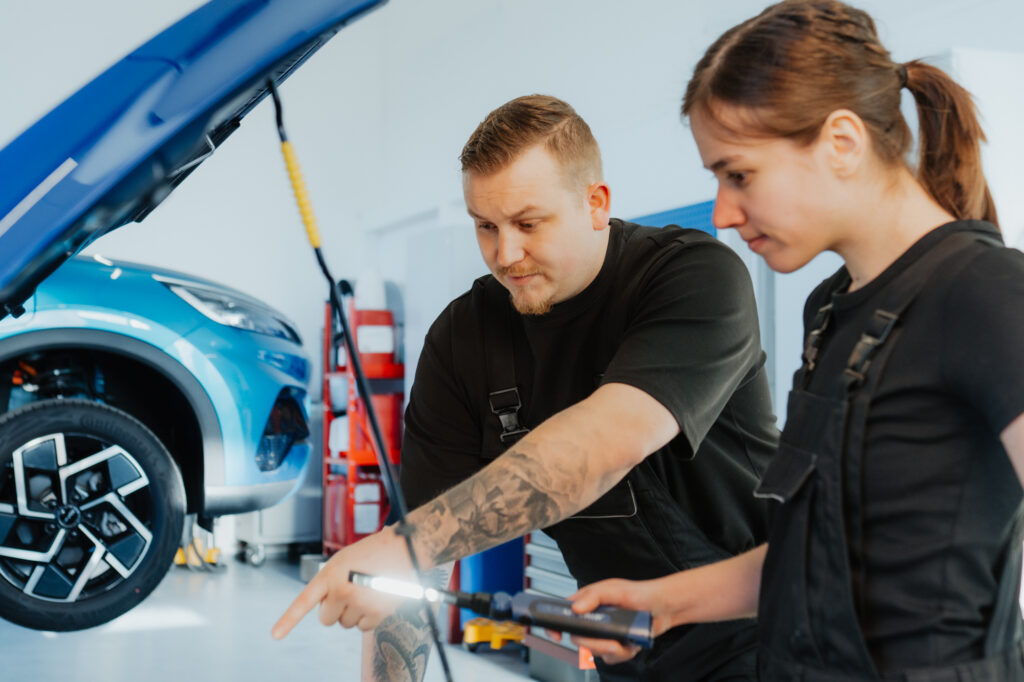 Zwei Garagisten am pr&uuml;fen des Motores Wartung und Reparatur